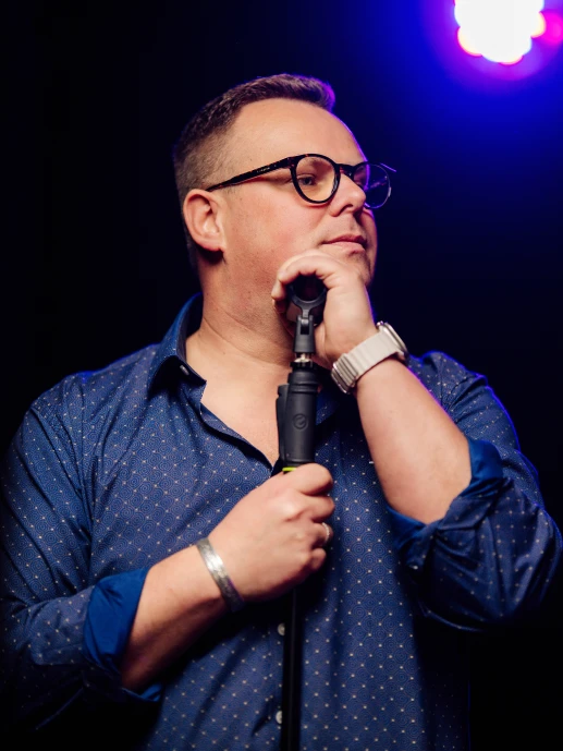 Bartek Michalczyk podczas występu na scenie, w ciepłym oświetleniu.